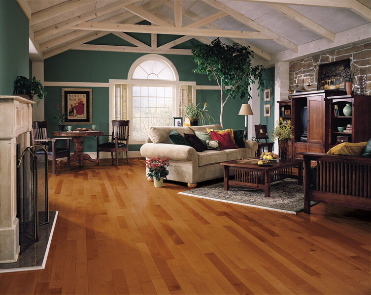 Living room with beams and a large window with medium toned hardwood floors