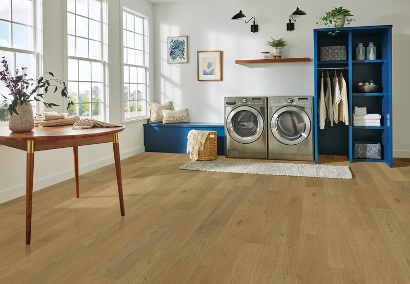 Hybrid resilient flooring in a laundry room with a washer and dryer and picture windows